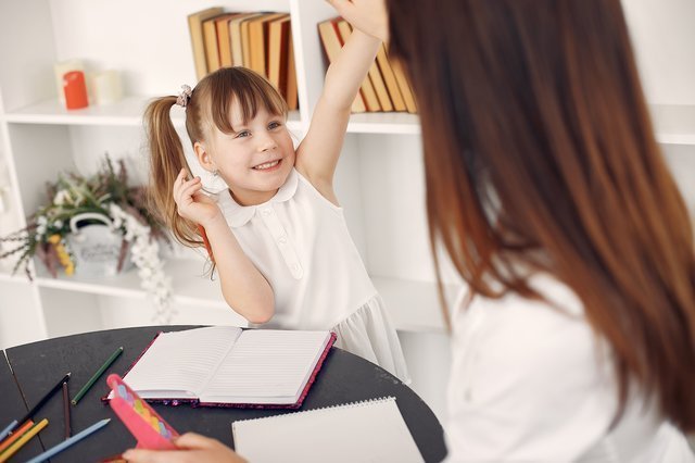 a little girl learning from a tutor