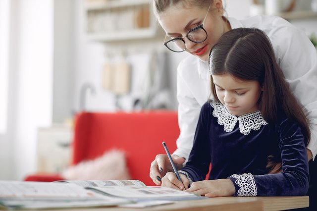 a tutor drawing with a young student||a tutor teaching a little girl